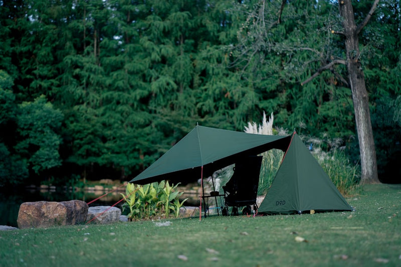 a couple of tents sitting on top of a lush green field