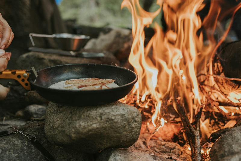 Cooking food in a skillet over a campfire