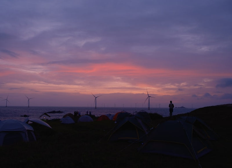 Camping site with wind turbines at sunset
