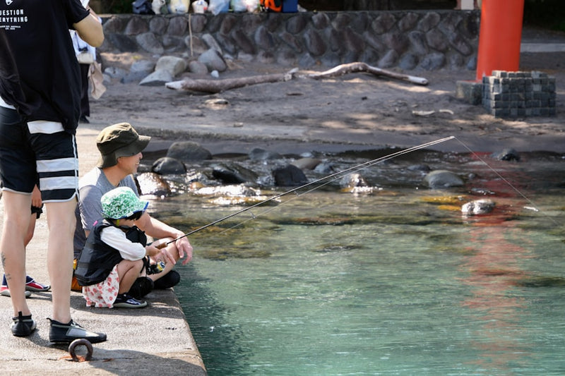 Adult and child by clear water