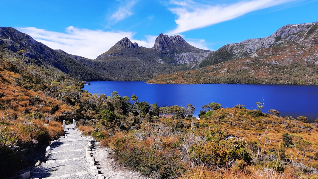 a path leading to a lake surrounded by mountains