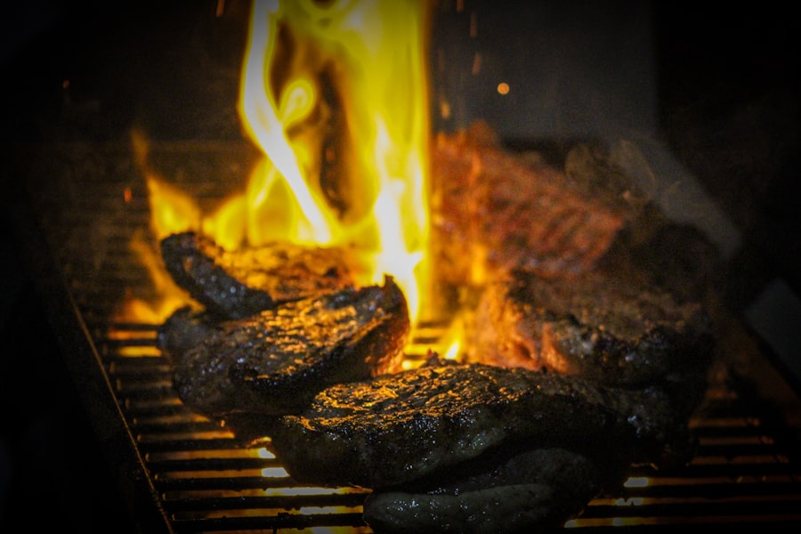 Steaks cooking over open flames on a grill.