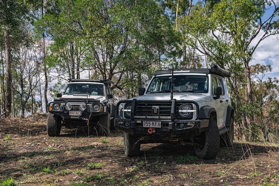 Two off-road vehicles parked in a wooded area.