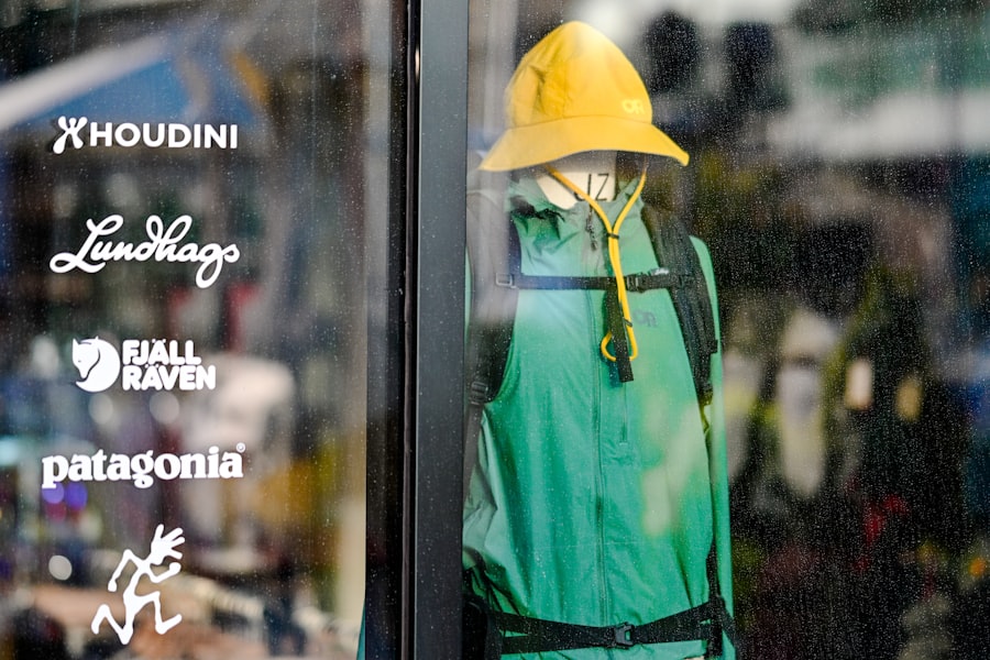 Mannequin in green jacket and yellow hat in store window.