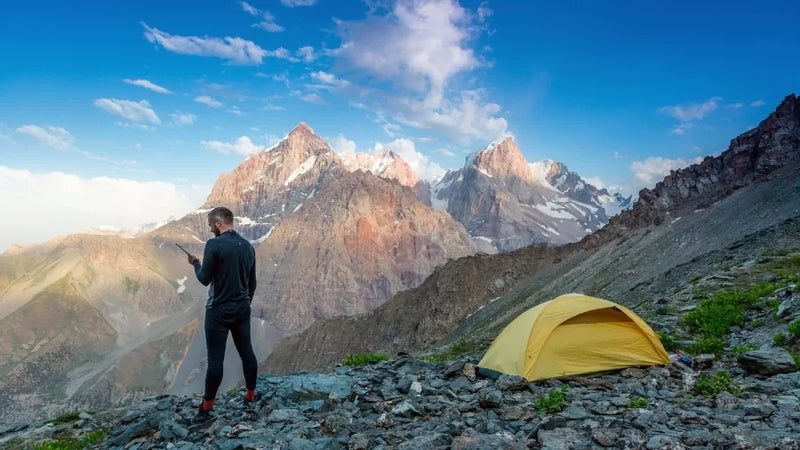 Man Camping with Communication and Navigation Tools