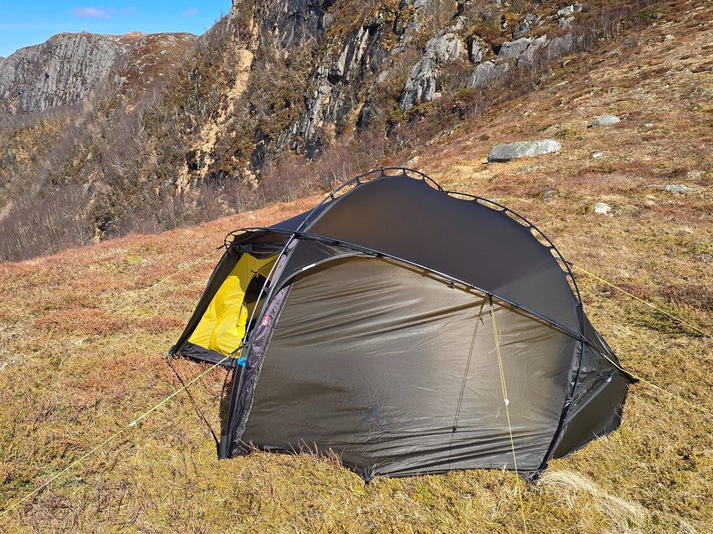 Nortent Vern 2 3S 2-person 3-season hiking tent – side view with fly closed below a rocky cliff